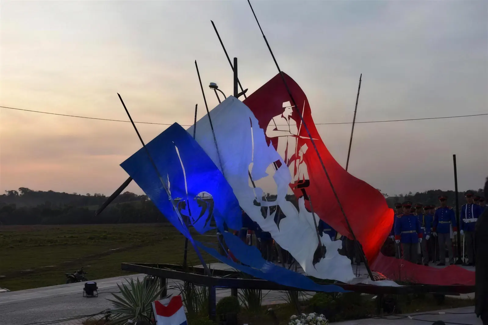 Monumento a los Niños Mártires de Acosta Ñu, con la bandera paraguaya recortada en chapa y las siluetas de un soldado y un niño